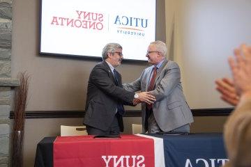 利记sbo and SUNY Oneonta Presidents shake hands at the signing of an Articulation Agreement between the two schools on 1月24日, 2024.