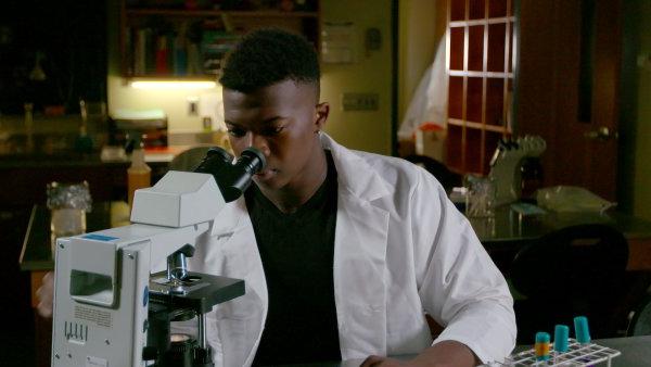 Dr Ivan Iton '21 looks through microscope